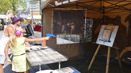 Een meisje doet aan paintball tijdens het Kunstfestival