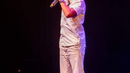 Optreden jongen met microfoon tijdens Regentes talentenshow 