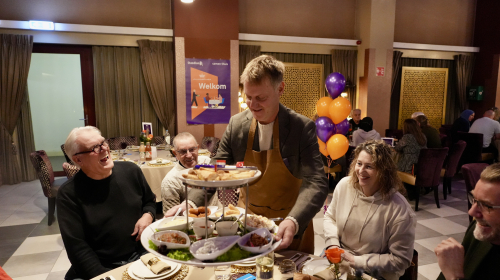Gijsbert van Herk deelt eten uit tijdens het ontmoetingsdiner