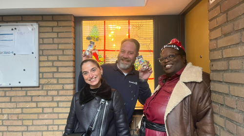 Medewerkers van Staedion delen kerstkransjes uit aan bewoner