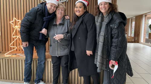Staedion deelt kerstkransjes uit aan bewoner in de entree 