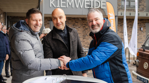 Drie mannen geven een handdruk om de overdracht te bezegelen