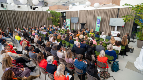 Sfeerfoto van het publiek van achter genomen van het congres 'Samen bouwen aan leefbare wijken'