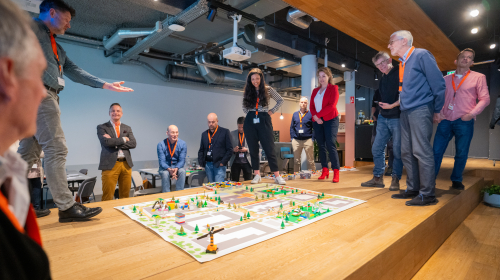 Creatieve workshop met een groot spelbord op de grond tijdens congres 'Samen bouwen aan leefbare wijken'