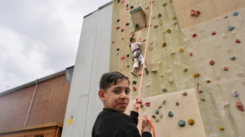 Jongen en meisje aan het klimmen op de klimmuur