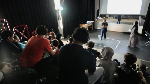 Grotere kinderen aan het kijken naar een theaterstuk