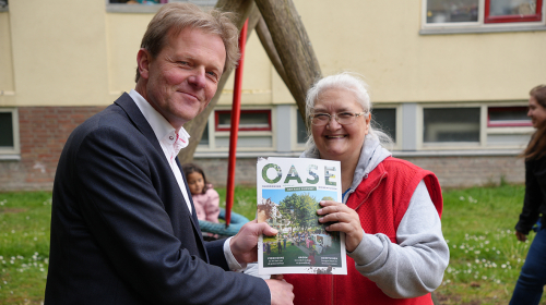 Chris Schaapman, directeur Nationaal programma Zuidwest, overhandigt het 1ste exemplaar van de handreiking aan een bewoner van de Middenstede
