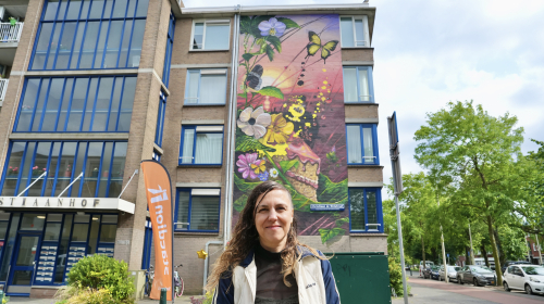 Nadia van Luijk voor haar muurschildering aan de Christiaan de Wetstraat