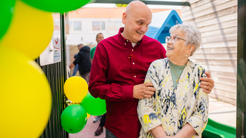 Moeder en zoon houden elkaar vast en kijken lachend naar elkaar