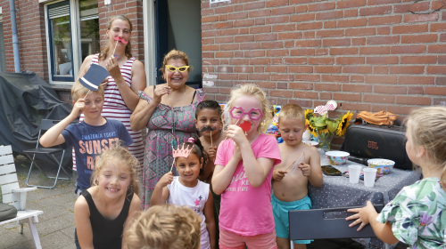 Kinderen tijdens het buurtfeest met vrolijke attributen voor hun gezicht