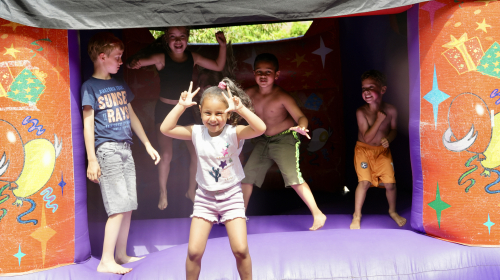 Kinderen tijdens het buurtfeest op het springkussen