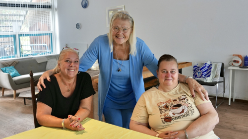 3 dames poserend voor de camera, 1 staat en 2 zitten