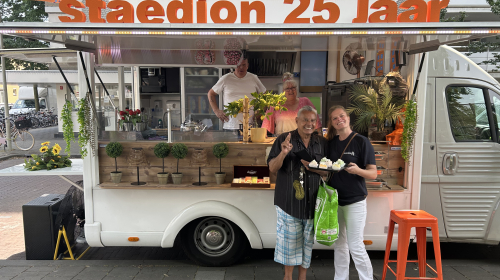Edwin en Coby Smulders in hun traktatiebus, met een medewerker van Staedion en een bewoner voor de bus