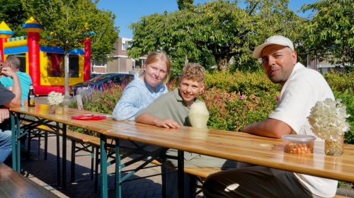 Jong en oud aan tafel in de Steve Bikostraat