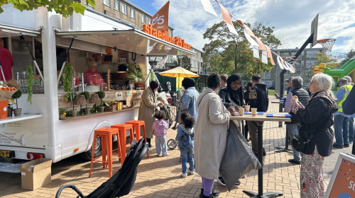 Bewoners praten met elkaar voor de traktatiebus