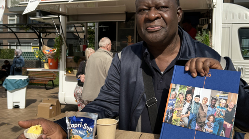 Meneer met het jubileumboek voor de traktatiebus