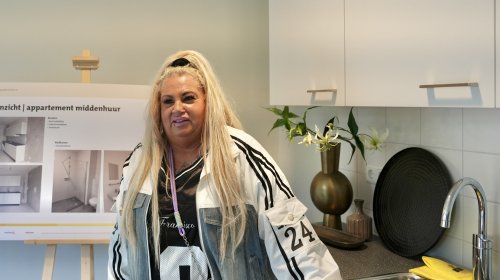 Dame staat in de keuken van een modelwoning