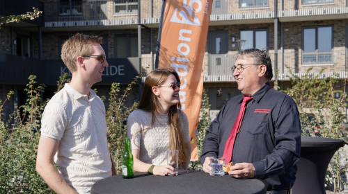 Drie mensen in gesprek, twee mannen en een vrouw