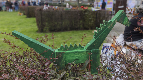 Houten groen geverfde houten dinosaurus van een kind tijdens festival De Betovering