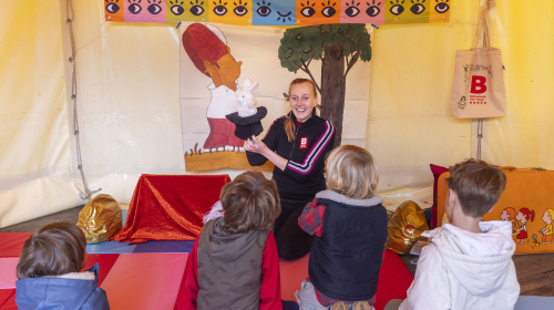 Dame van bibliotheek leest verhaal voor aan kinderen