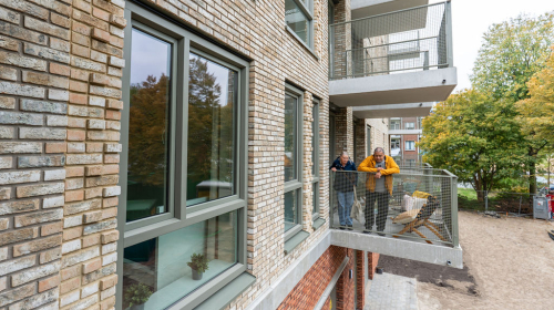 Een balkon met twee mensen erop in het nieuwe gebouw