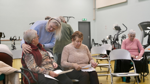 Drie koorleden nemen de tekst door