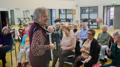 orkestleider Fredrike begeleidt het koor op accordeon