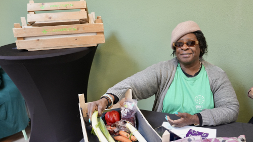 Norine zit bij de weggeeftafel van Stichting Quiet