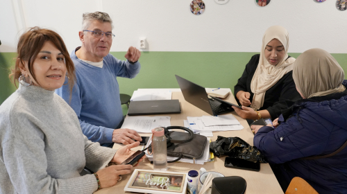 Twee adviseurs en twee mensen die advies vragen aan een tafel