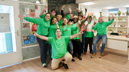 Een groep vrijwilligers van Stichting Quiet poseert voor de foto in hun nieuwe pand aan het Joubertplantsoen