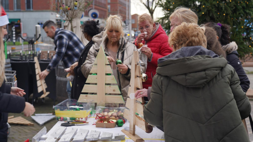 Bewoners versieren samen kerstboom bij oliebollenactie Ypenburg