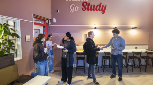 Collega Miranda in gesprek met studenten tijdens de opening van de studieruimte in De Struyck