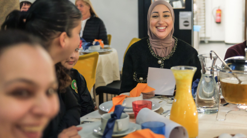 Lachende bewoners tijdens de feestmaaltijd op 9 maart