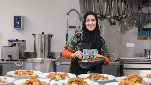 Vrijwillger van de Participatie Keuken tijdens de feestmaaltijd op 9 maart