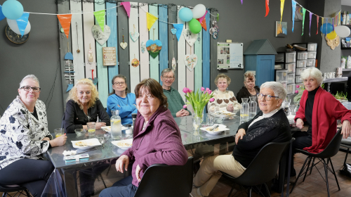 De tafel vol bezoek in de Buurtkamer.