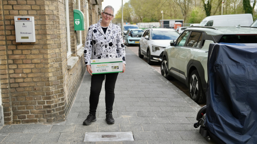 Een mevrouw met in haar handen een waardebon voor de Gulden Klinker