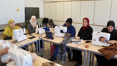Salima geeft naailes, ze zit tussen de dames die aan het werk zijn