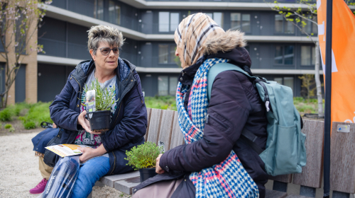 Bewoners praten gezellig op een bankje bij het welkom van de Schaloen