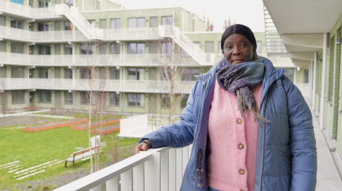 Mevrouw staat op haar galerij van het nieuwe huis in Steenzicht.
