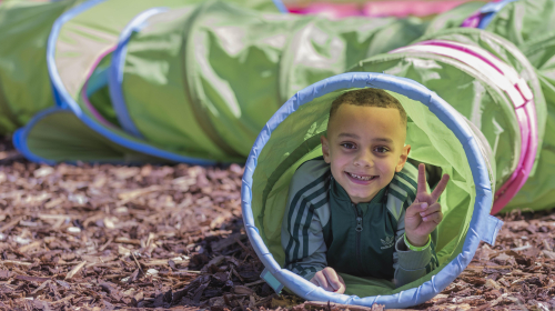 Een kind speelt in een kruiptunnel