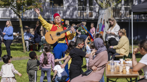 Een artiest zingt samen met kinderen een lied