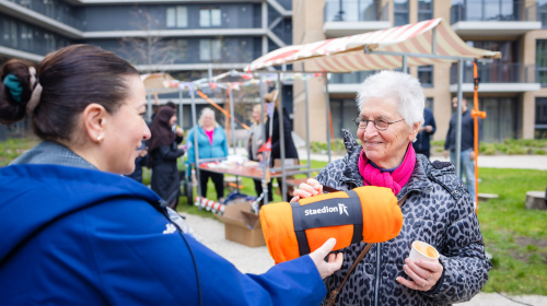 Collega geeft mevrouw een cadeau als welkom bij de Schaloen