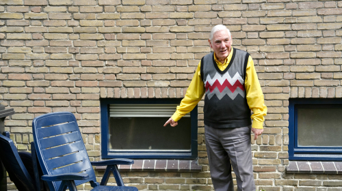 Pim laat van buiten het raam van de blueskelder zien