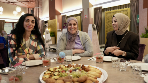 Drie dames aan tafel, te gast