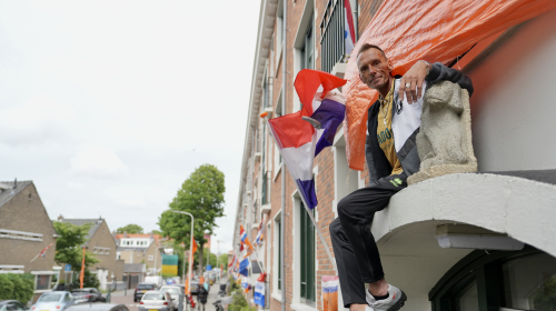 Mike op zijn afdak tussen de Nederlandse vlaggen.