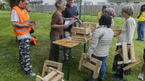 Mensen luisteren aandachtig naar uitleg over het maken van de plantenbak voor het balkon