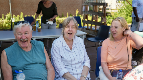 Drie bewoners van de Liszstraat op een bankje aan het kletsen