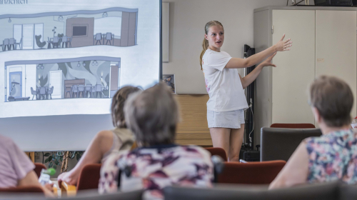 Een leerling vertelt over haar ontwerp aan de groep