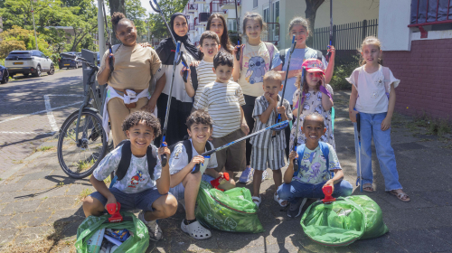 Een foto van een groep kinderen die afval gaan opruimen op straat