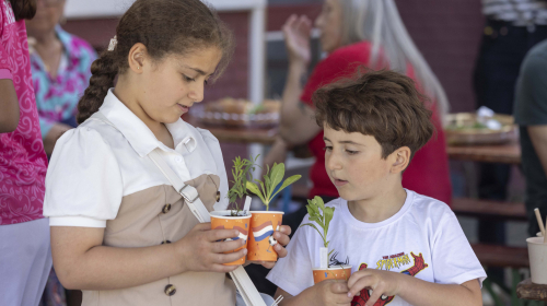Twee kinderen bezig met het planten van plantjes